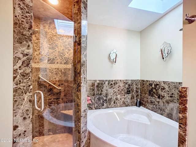 bathroom featuring independent shower and bath and a skylight