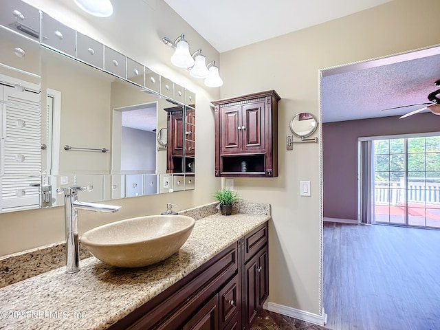 bathroom with hardwood / wood-style flooring, ceiling fan, and vanity