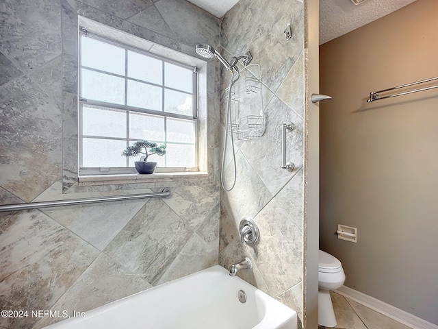 bathroom featuring tile patterned floors, a textured ceiling, tiled shower / bath combo, and toilet