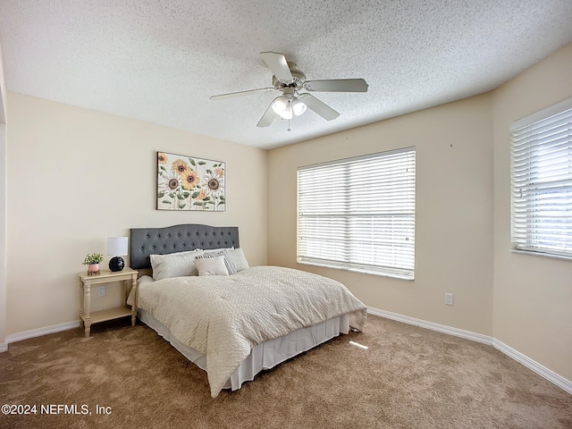 bedroom with carpet flooring, a textured ceiling, and ceiling fan