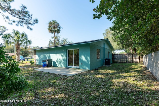 rear view of property with central AC, a yard, and a patio area