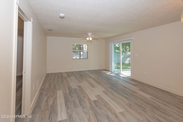 empty room featuring ceiling fan, a textured ceiling, and light wood-type flooring