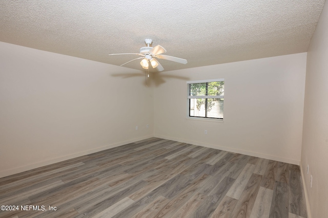 empty room featuring a textured ceiling, dark wood-type flooring, and ceiling fan