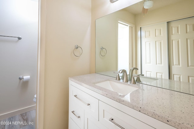 bathroom with vanity, hardwood / wood-style flooring, and toilet