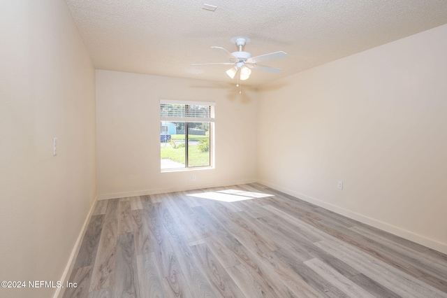 empty room featuring light hardwood / wood-style floors, a textured ceiling, and ceiling fan