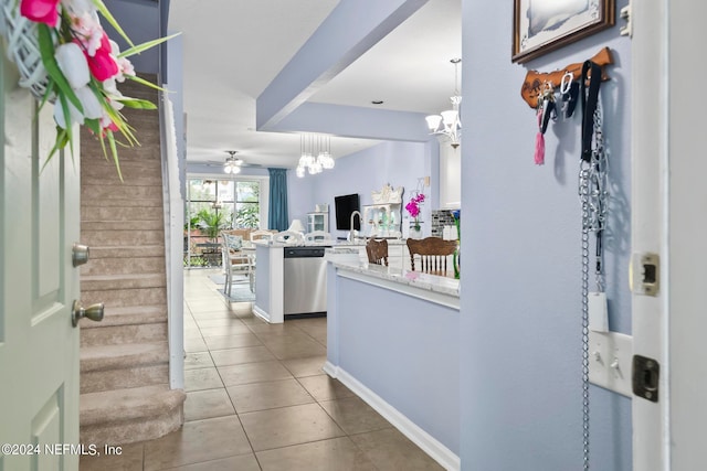 tiled foyer entrance with ceiling fan with notable chandelier