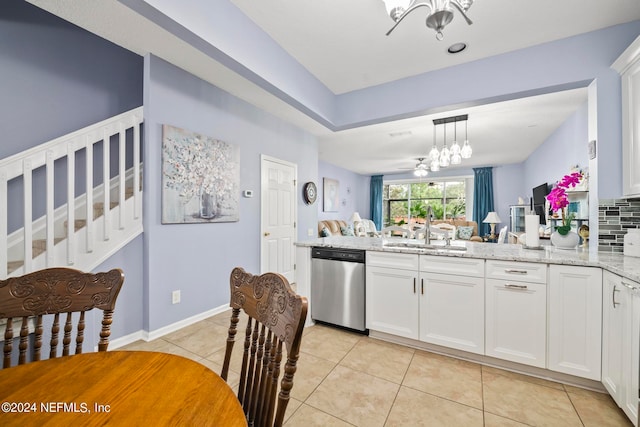 kitchen with light stone countertops, stainless steel dishwasher, white cabinetry, and sink