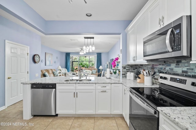 kitchen featuring white cabinets, kitchen peninsula, appliances with stainless steel finishes, and sink