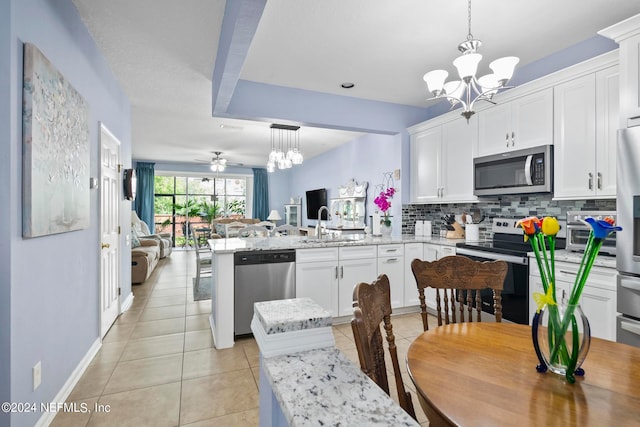 kitchen featuring kitchen peninsula, a kitchen bar, pendant lighting, and stainless steel appliances