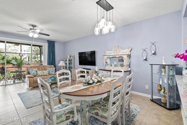 tiled dining room featuring ceiling fan with notable chandelier and a textured ceiling