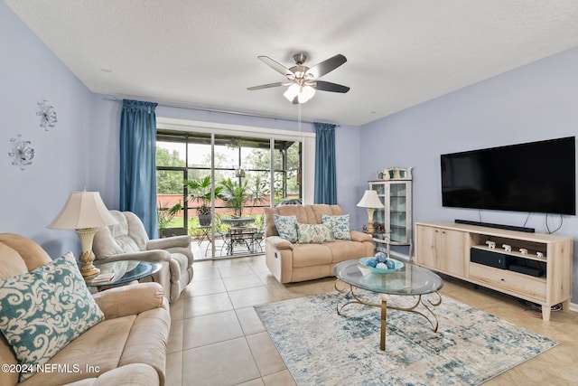 living room with ceiling fan, a textured ceiling, and light tile patterned floors