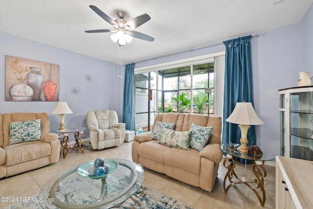 living room featuring a textured ceiling, light tile patterned floors, and ceiling fan