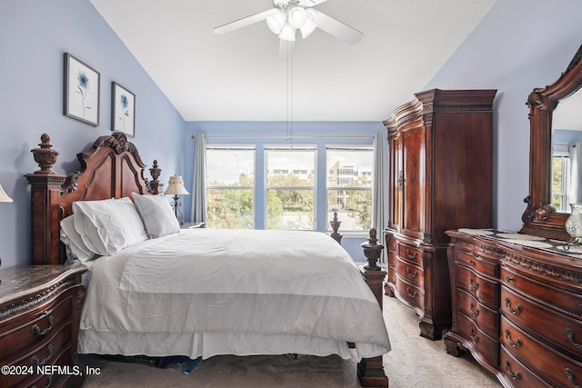 bedroom with multiple windows, vaulted ceiling, ceiling fan, and light colored carpet