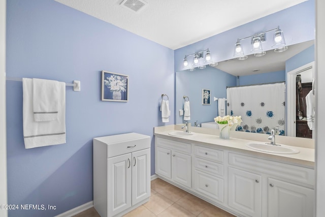 bathroom with tile patterned floors, a textured ceiling, a shower with curtain, and vanity