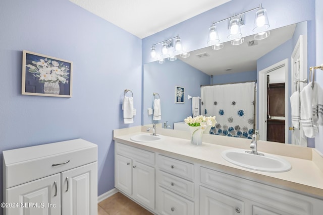 bathroom with tile patterned floors, walk in shower, and vanity