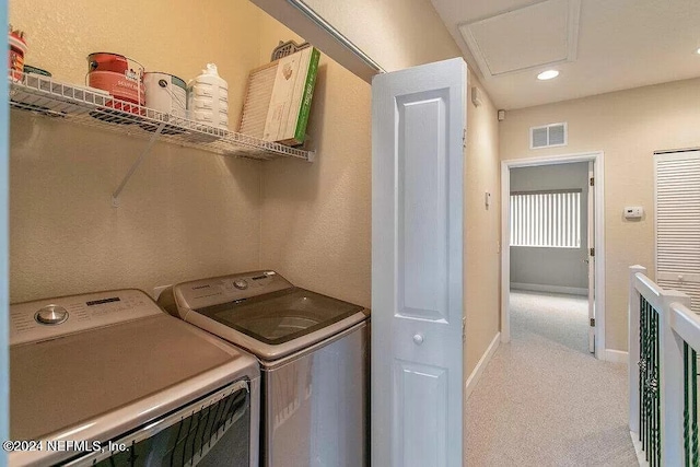 laundry room featuring light carpet and washer and dryer