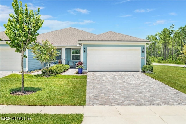 view of front of home with a front yard and a garage