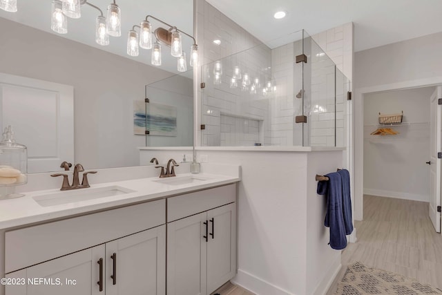 bathroom with a tile shower and vanity