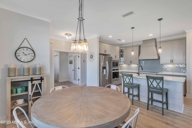 dining space featuring light hardwood / wood-style flooring and ornamental molding