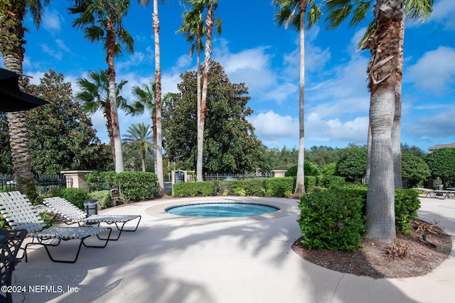 10961 Burnt Mill Rd Unit 421, Jacksonville, FL 32256 - view of swimming pool with an in-ground hot tub, a patio area, and view of wooded area