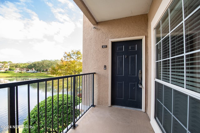 property entrance featuring a water view and a balcony