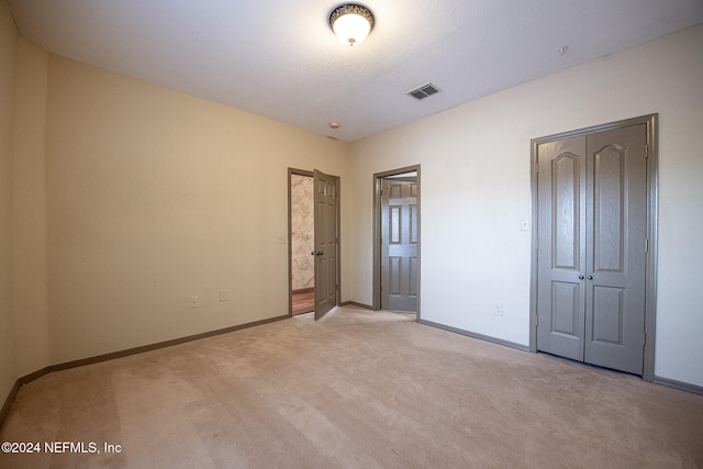 unfurnished bedroom featuring light carpet