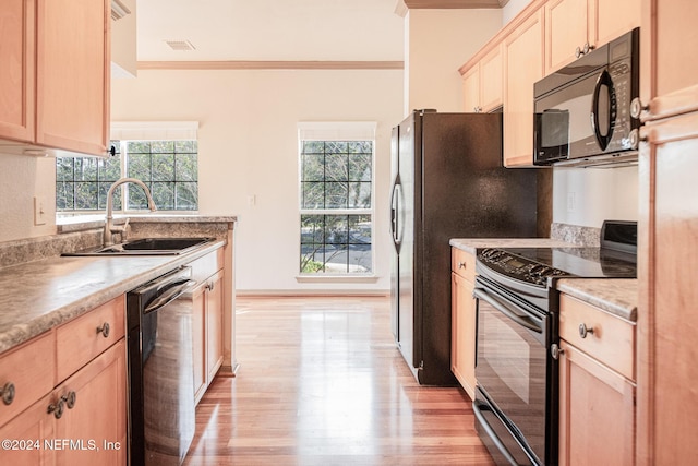 10961 Burnt Mill Rd Unit 421, Jacksonville, FL 32256 - kitchen with black appliances, light brown cabinetry, crown molding, light wood-type flooring, and light countertops