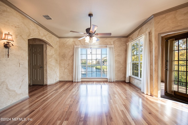 empty room with crown molding, ceiling fan, and light hardwood / wood-style flooring