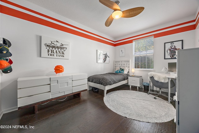 bedroom featuring dark wood-type flooring, ceiling fan, and a textured ceiling