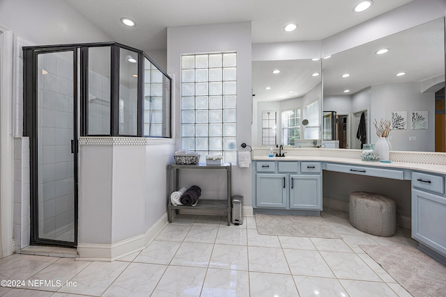 bathroom featuring a shower with door and vanity