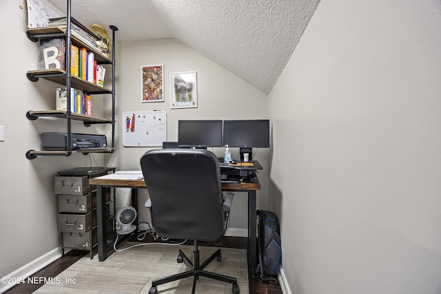 office space featuring hardwood / wood-style flooring, vaulted ceiling, and a textured ceiling