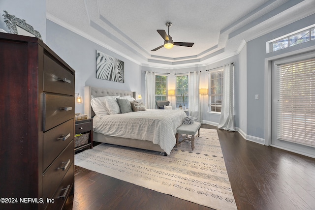 bedroom with dark hardwood / wood-style flooring, access to exterior, crown molding, and a raised ceiling