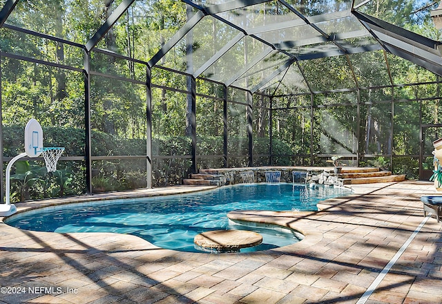 view of pool with pool water feature, a patio, and glass enclosure