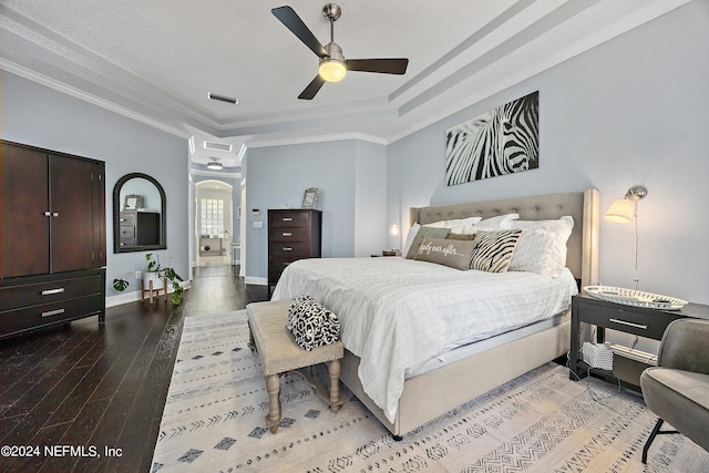 bedroom featuring hardwood / wood-style floors, crown molding, a raised ceiling, and ceiling fan