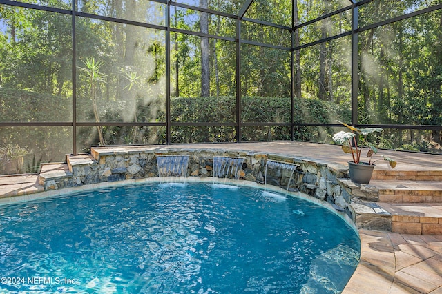 view of pool featuring pool water feature, glass enclosure, and a patio area