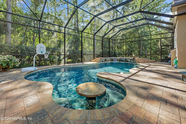 view of pool featuring pool water feature, a lanai, and a patio