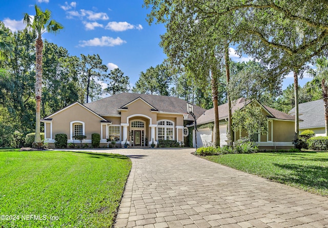 ranch-style house featuring french doors, a garage, and a front lawn