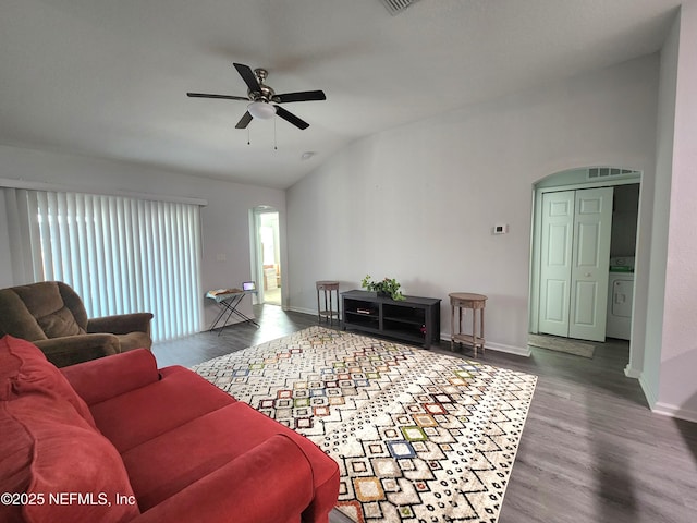 living room featuring wood-type flooring, washer / dryer, lofted ceiling, and ceiling fan