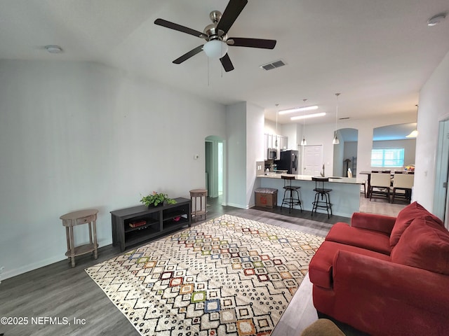 living room featuring dark wood-type flooring and ceiling fan