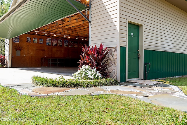 entrance to property with a yard and a patio area