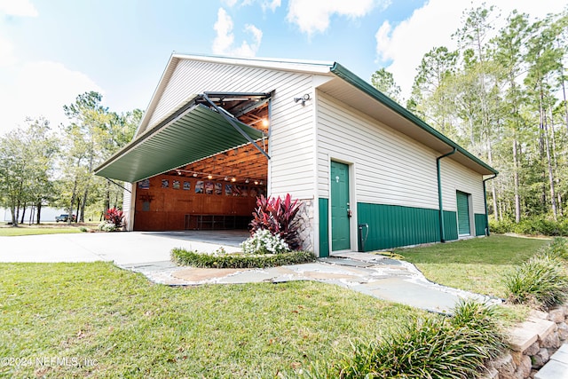 view of side of home featuring a garage and a lawn