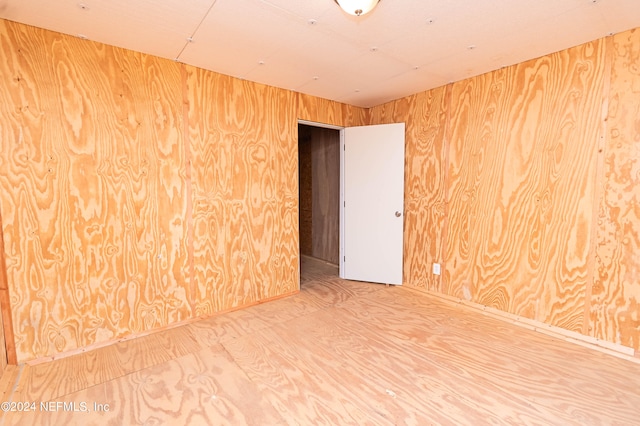 spare room featuring wood walls