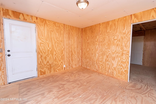 unfurnished room with wooden walls