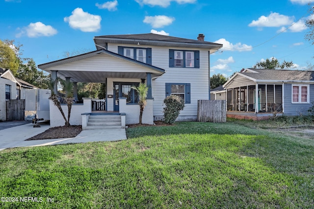 view of front of house featuring a sunroom, a front yard, and a porch