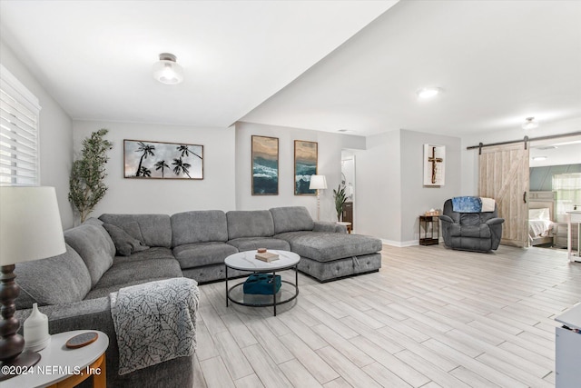 living room featuring a barn door and light hardwood / wood-style floors