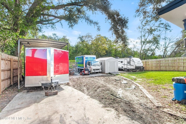 view of yard with a storage shed and a patio