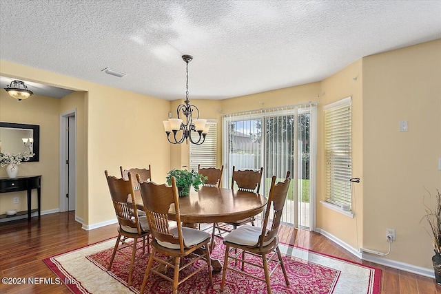 dining room with a notable chandelier, a textured ceiling, and dark hardwood / wood-style floors