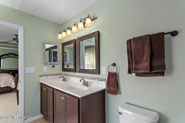 bathroom featuring vanity, toilet, a textured ceiling, and ceiling fan