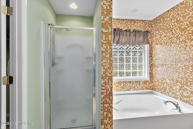 bathroom featuring shower with separate bathtub