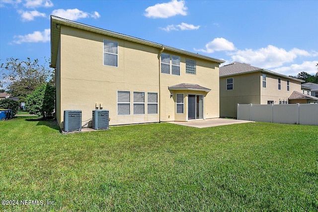 rear view of house featuring a patio area, cooling unit, and a lawn